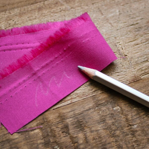 PRYM značkovací tužka stříbrná - ukázka stopy tužky na růžové látce.